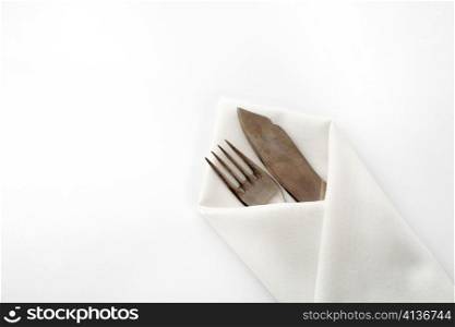 An image of a fork and knife in napkin