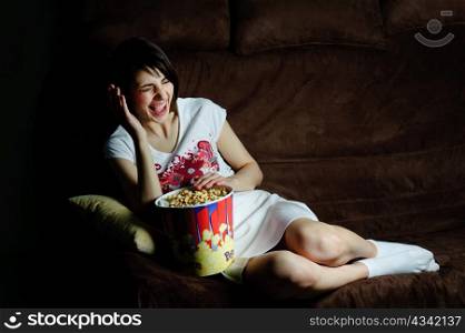 An image of a girl on a sofa laughing