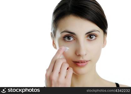 An image of a girl putting some cream onto her face