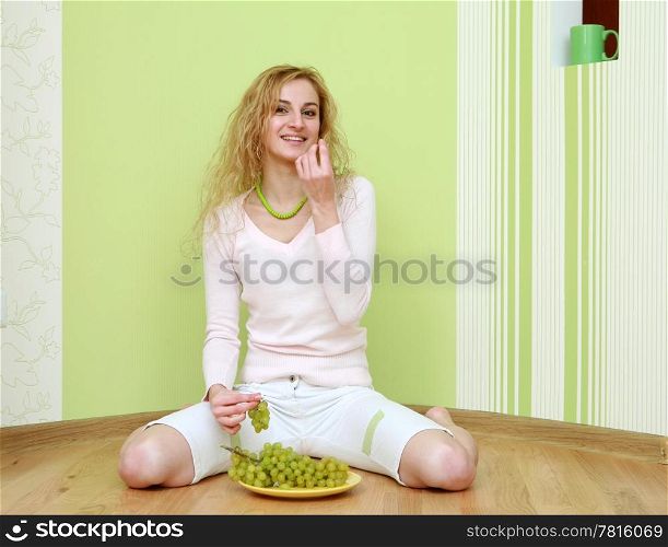 An image of a girl with a bunch of green grapes on plate