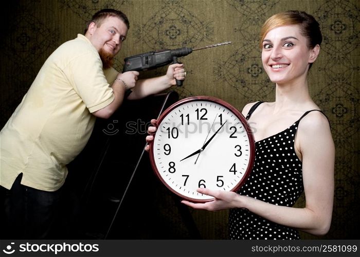 An image of a woman with new clock and a man with drill