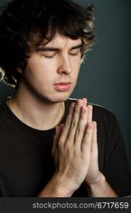 An image of a young man praying alone
