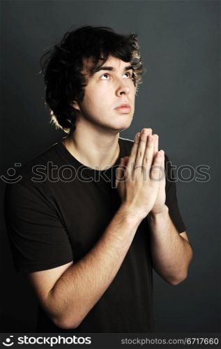 An image of a young man praying alone
