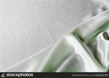 An image of folds of green glace cloth