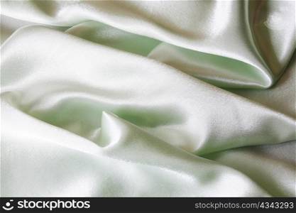 An image of folds of green shine cloth