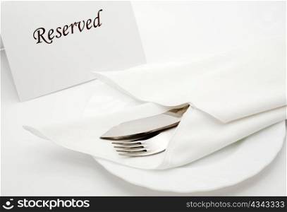 An image of fork and kife in napkin on the table