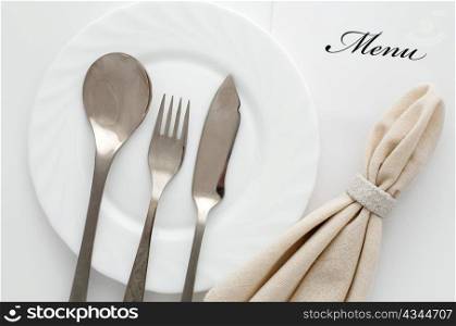 An image of fork, spoon and knife on a plate