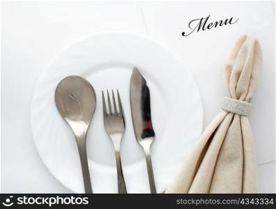 An image of fork, spoon and knife with napkin