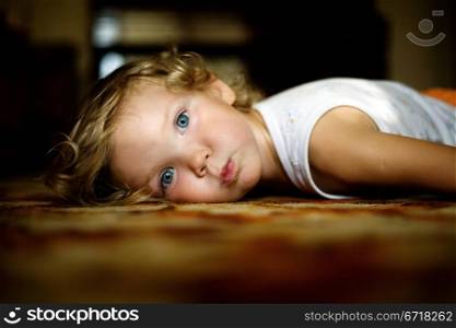 An image of little girl lying on the floor