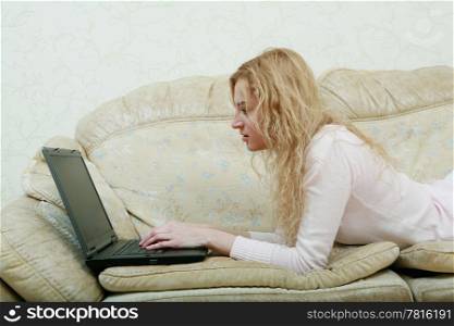An image of nice girl with laptop on a sofa