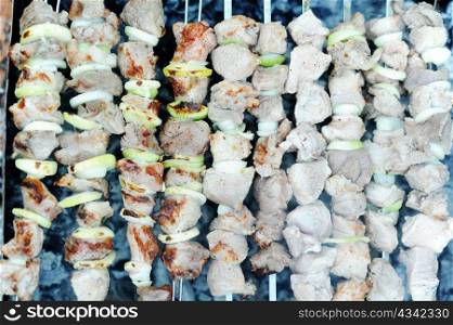 An image of raw meat and onions on skewers