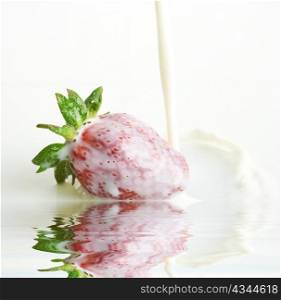 An image of red strawberry in a milk close up