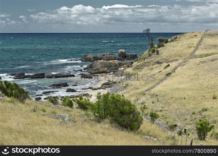 An image of the australian coast with rock, sand and the sea