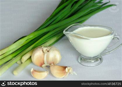 An image of white souce and green onion with garlic