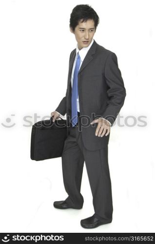 An indecisive asian businessman in grey suit