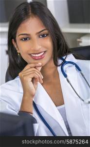 An Indian Asian female medical doctor in a hospital office happy and smiling with stethoscope&#xD;