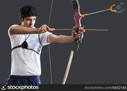 An Indian male archer aiming over black background