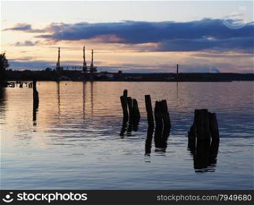 an industrial city on the shore of lake at sunset