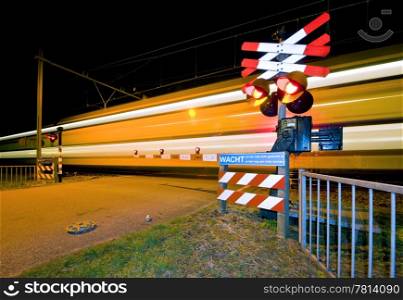 An intercity passing a railroad crossing at night