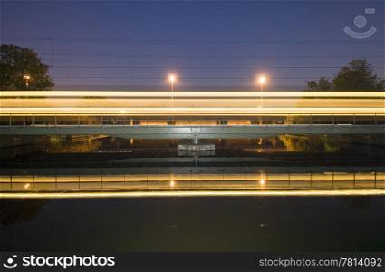 An intercity racing over a railway bridge at night