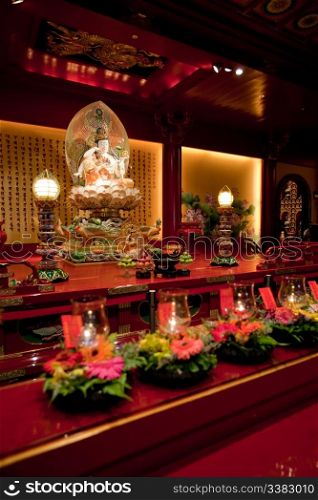 An interior of a Buddhist temple with a Buddha statue
