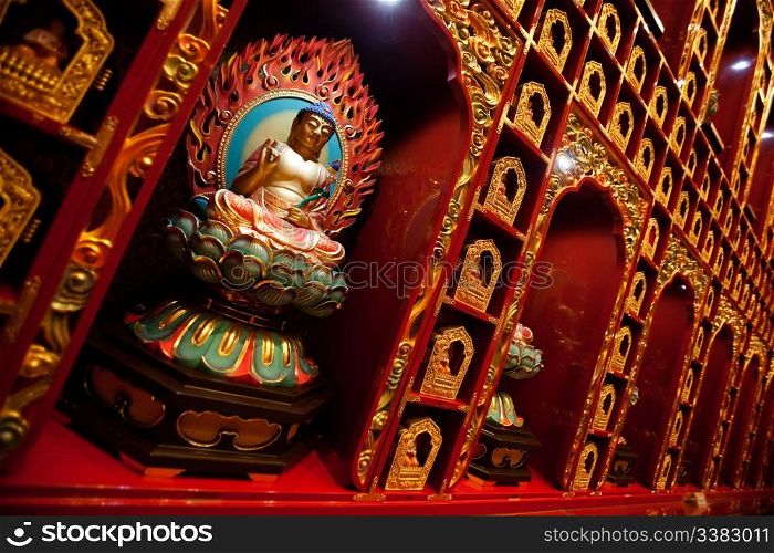 An interior of a buddhist temple with many Buddha statues.