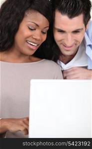 an interracial couple doing computer