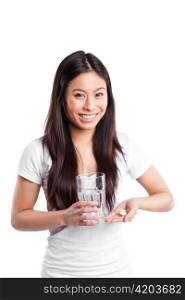 An isolated shot of a beautiful asian woman taking her vitamins