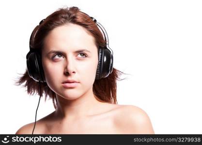 An isolated shot of a beautiful caucasian woman listening music with headphones