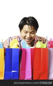 An isolated shot of a happy young man with shopping bags