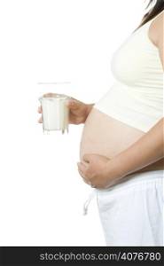 An isolated shot of a pregnant woman drinking a glass of milk