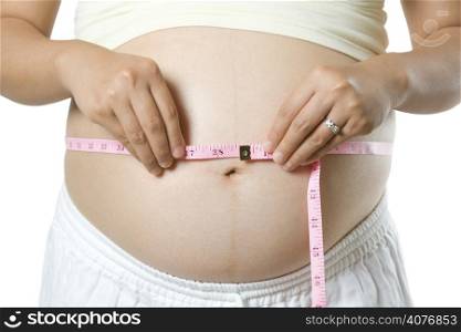 An isolated shot of a pregnant woman measuring her stomach
