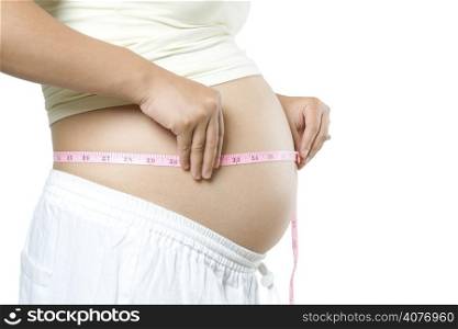 An isolated shot of a pregnant woman measuring her stomach