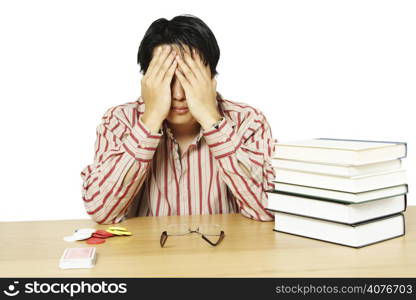 An isolated shot of a stressed young man undecided between studying or playing cards