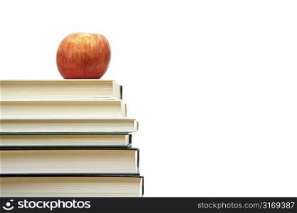 An isolated shot of an apple on top of books