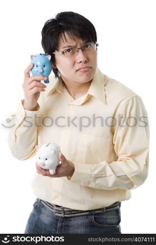 An isolated shot of an asian businessman listening to a piggy bank