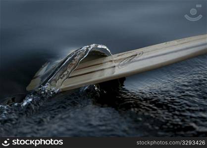 An oar passing through the water on the lake at Lake of the Woods, Ontario