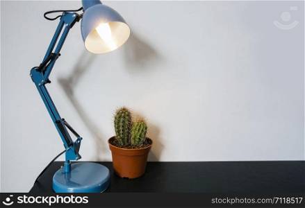 An office desk lamp, modern workspace with cactus, space for text black table. An office desk lamp, modern workspace with cactus, space for text