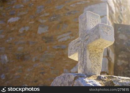 An old, ancient, medieval cross on a tombstone. Signs, symbols of Christian culture.. Medieval cross on a tombstone