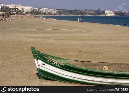 An old boat, filled with sand, is used as a barbecue pit on the beach at Estepona on Spain&rsquo;s Costa del Sol.