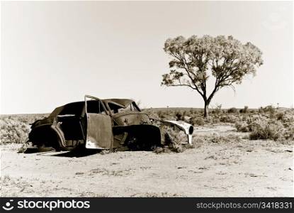 an old car rusts away in the hot australian desert. old car in the desert