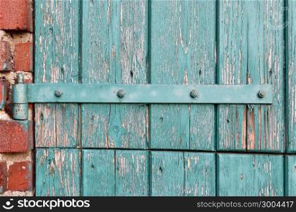 An old door hinge of old wooden door with weathered paint in Zelhem, The Netherlands.