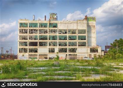 An old factory in the Highland Park area shows the post-industrial plight of Detroit with broken windows and a parking lot filled with weeds.