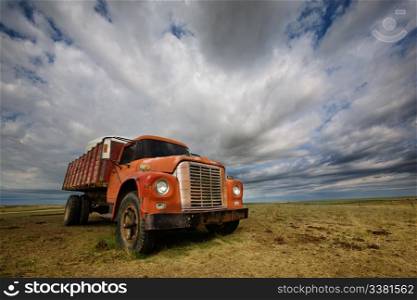 An old farm truck against a dramatic prairie landscape