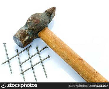 An old hammer with a wooden handle and a bunch of nails. Objects on a light background. Old hammer and nails. Objects on a light background