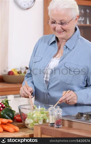 An old lady making a salad.