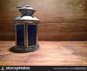 An old lamp on a wooden table