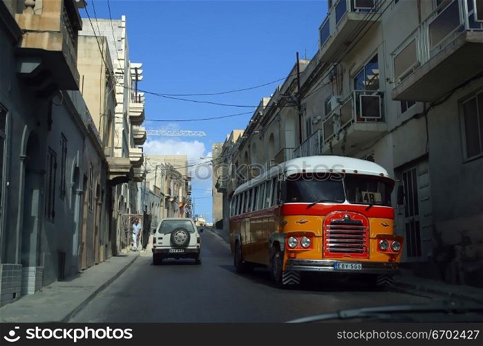 An old Maltese bus rattles along the road of Valetta.