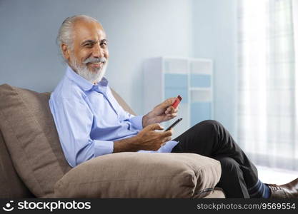 AN OLD MAN HAPPILY SITTING AT HOME AND DOING ONLINE TRANSACTIONS