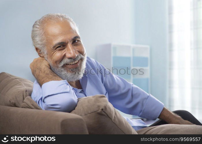 AN OLD MAN LAUGHING WHILE LOOKING AT CAMERA